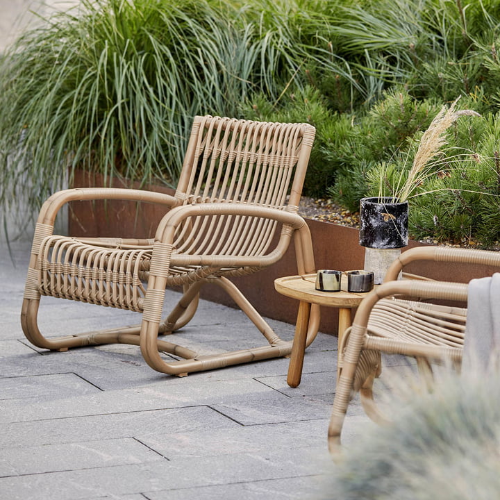 La chaise longue Curve Outdoor de Cane-line sur la terrasse verte plantée