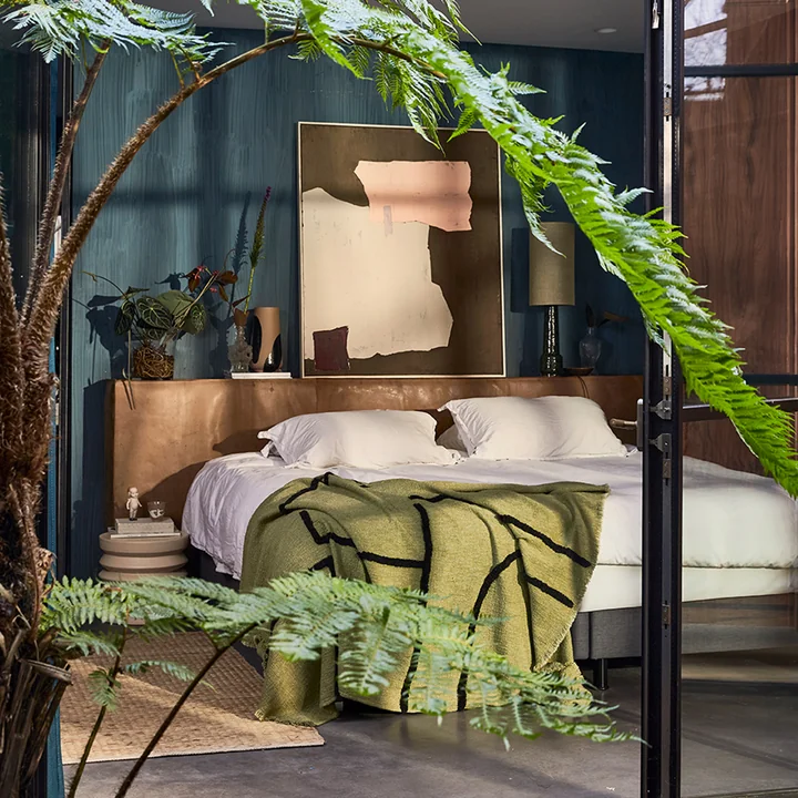 Le tapis de jute à côté d'un lit avec couverture de HKliving