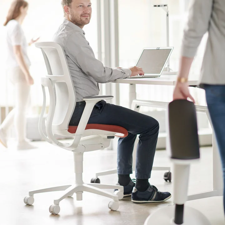 Le fauteuil pivotant de bureau ergonomique AT Mesh de Wilkhahn au bureau
