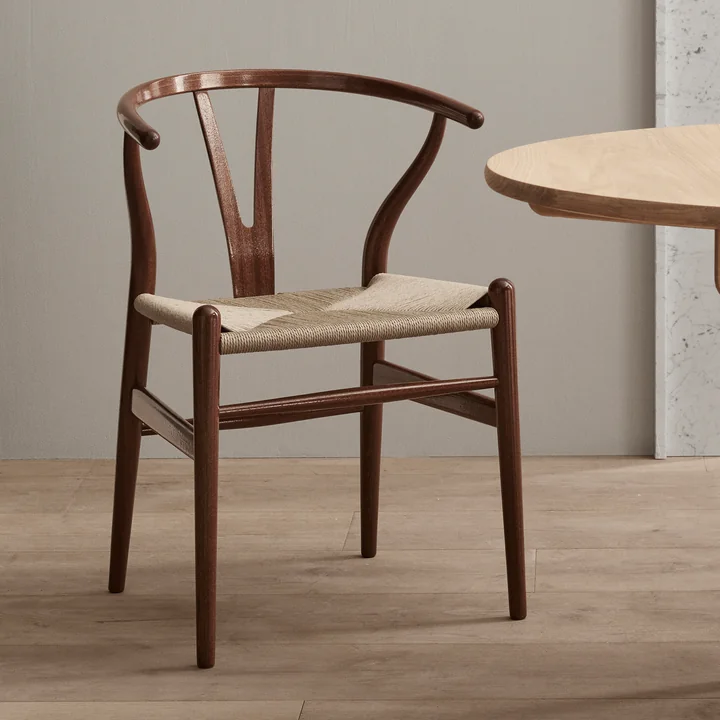 Le CH24 Wishbone Chair dans la Birthday Edition 2021 de Carl Hansen à côté d'une table en chêne
